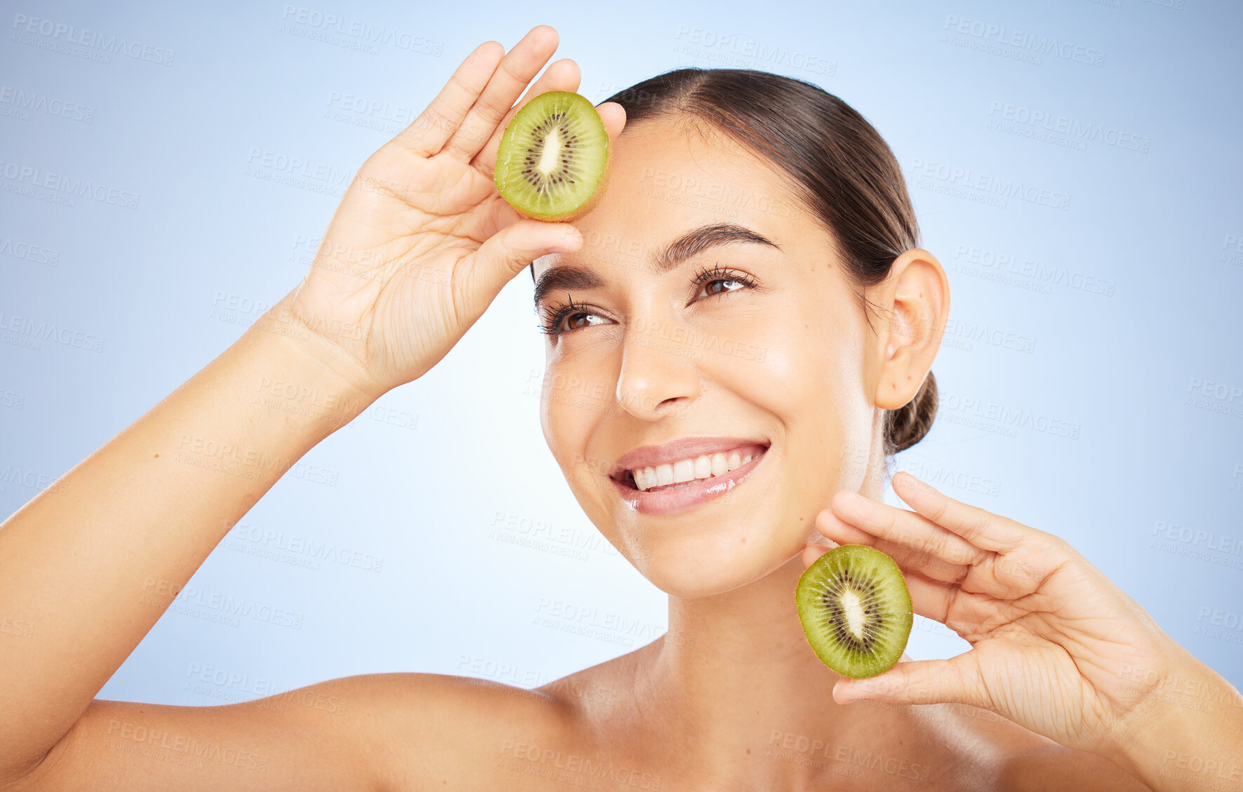 Buy stock photo Beauty, kiwi and woman with face and smile, skincare and organic, vegan cosmetic care for healthy skin. Microblading, natural cosmetics and hands frame with fruit, facial and glow on blue background.