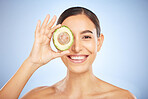 Face portrait, skincare and woman with avocado isolated on a blue studio background. Beauty, cosmetics and young female model with fruit, food or product for nutrition, healthy fats and vitamin c.