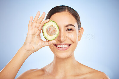 Buy stock photo Face portrait, skincare and woman with avocado isolated on a blue studio background. Beauty, cosmetics and young female model with fruit, food or product for nutrition, healthy fats and vitamin c.