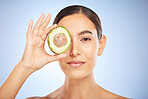 Face portrait, skincare and woman with avocado isolated on a blue studio background. Beauty, cosmetics and young female model with fruit, food or product for nutrition, healthy fats and vitamin c.