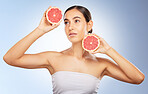 Woman, beauty and natural skincare with grapefruit, radiat glow and healthy aesthetic by blue background. Model, skin shine and fruit for wellness, self care and cosmetic health by studio background
