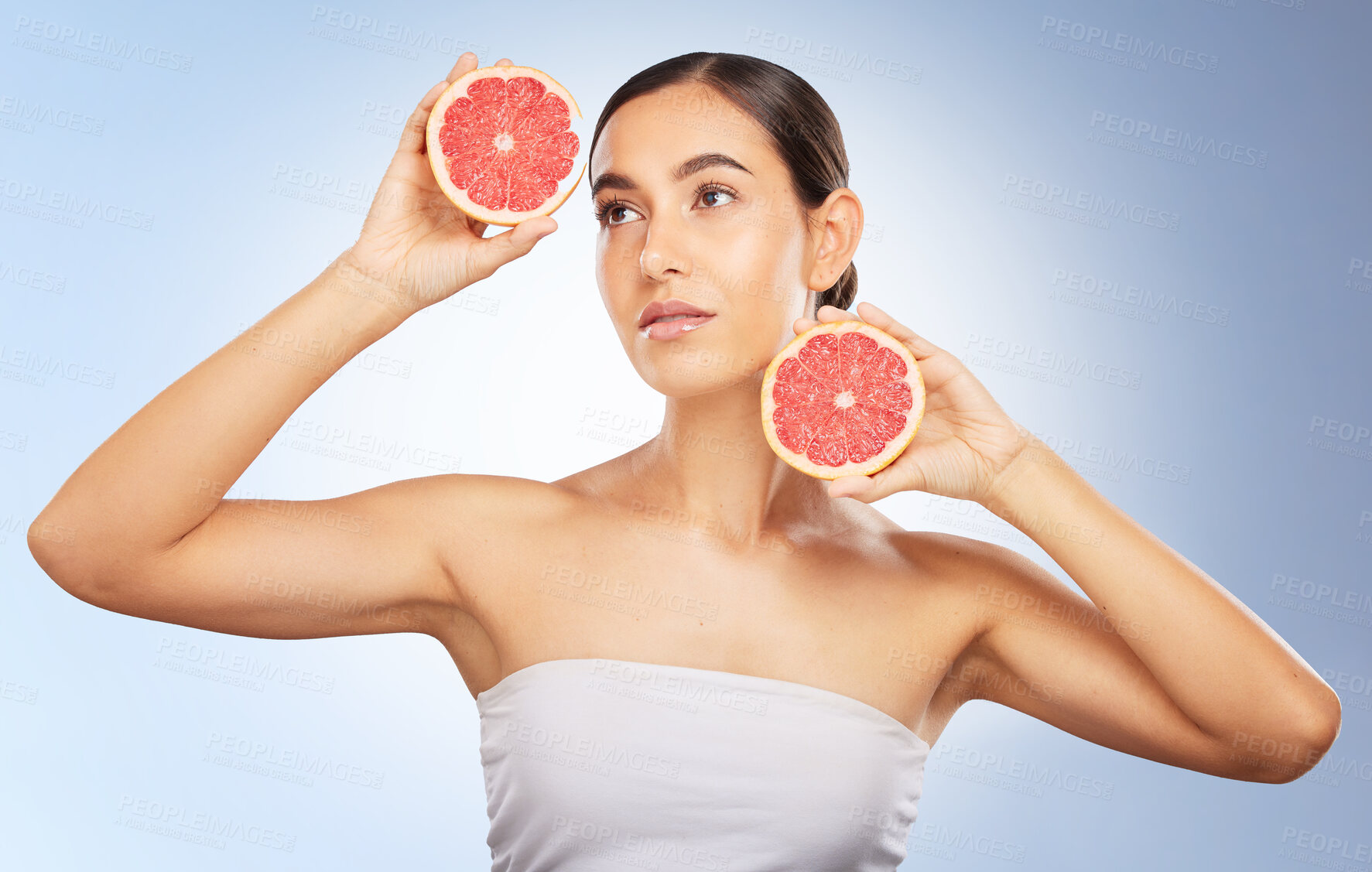 Buy stock photo Woman, beauty and natural skincare with grapefruit, radiant glow and healthy aesthetic by blue background. Model, skin shine and fruit for wellness, self care and cosmetic health by studio background
