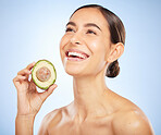 Woman, face or skincare glow with avocado on blue background in studio healthcare wellness, grooming routine or organic food dermatology. Smile, happy or beauty model with diet fruit for relax facial