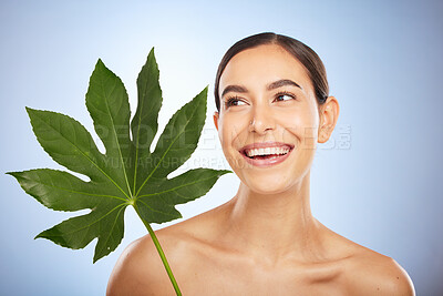 Buy stock photo Woman, skincare and plant leaf in studio for self care beauty, wellness and smile by blue background. Model, happy and monstera leaves for natural cosmetic, radiant skin glow or aesthetic by backdrop