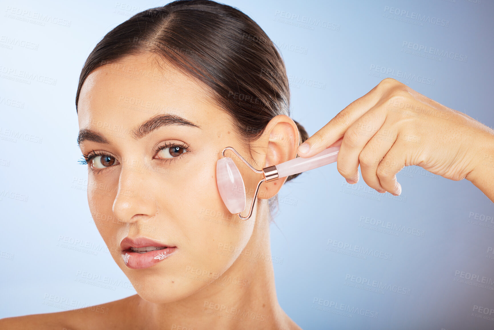 Buy stock photo Beauty, portrait or woman with a roller for skincare in facial grooming routine in studio with advertising mockup space. Product, luxury or girl model with cosmetics, natural glowing or smooth face
