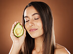Beauty with avocado for facial, skincare and woman with face care, healthy skin with organic and vegan cosmetic treatment against studio background. Calm, wellness and glow with natural cosmetics.
