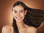 Face portrait, hair care and beauty of woman in studio isolated on a brown background. Wellness, hairstyle and aesthetics of female model with healthy and long hair after salon treatment for growth.