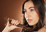 Hair, beauty and skincare with a model woman in studio on a brown background for natural or keratin treatment. Face, haircare and salon with an attractive young female posing to promote a product