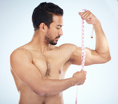 Buy stock photo Fitness, body and man with tape measure for biceps in studio on a blue background. Sports, exercise goals and male measuring arm for training, workout or muscle growth progress, results or target.