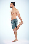 Fitness, health and man stretching leg in studio isolated on a blue background mock up. Sports, body wellness and young male athlete stretch, warm up and preparing for workout, exercise and training.