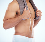 Body, fitness and man with towel in studio after shower, cleaning or bathing for hygiene, health and wellness on blue background. Skincare, body care or male model with cloth for drying after washing