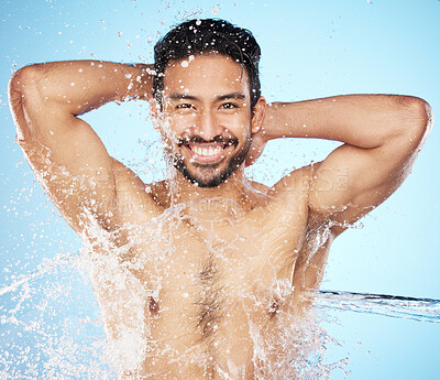 Buy stock photo Portrait, water and shower with a man model in studio on a blue background for hygiene or hydration. Face, beauty and skincare with a handsome young male wet from a water splash in the bathroom
