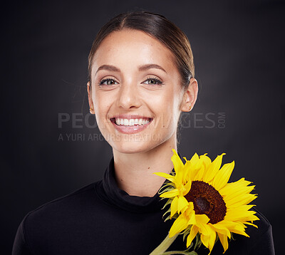 Buy stock photo Skincare, beauty and portrait of a woman with a sunflower in a studio for a clean, healthy and organic routine. Cosmetic, floral and model from Brazil with natural face treatment by black background.