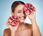Face portrait, skincare and woman with pomegranate in studio on a blue background. Organic cosmetics, beauty and female model with product, fruit or food for vitamin c, nutrition and healthy diet.