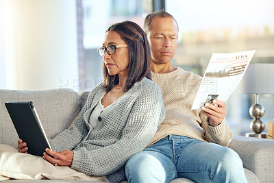 Buy stock photo Tablet, newspaper and couple relax on sofa, bonding and streaming video at home. Technology, love and mature man reading news and woman with touchscreen on social media or internet browsing in house.