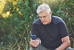 Fitness, phone or old man streaming a podcast, radio music or motivational audio for running exercise or workout. Wellness, relaxing or senior person listening to a song in headphones in nature park