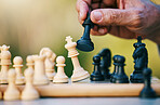 Chess, play or hand with a king on a board game with a winning strategy in a tournament outdoors in nature. Checkmate, mindset or smart man playing in a sports contest or problem solving challenge 