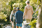 Hiking, fitness and elderly with people in the park for exercise, senior hiker group together with retirement and trekking back view. Hike, active lifestyle and wellness with vitality and friends.
