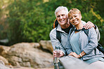 Nature, hiking and portrait of a senior couple relaxing while walking in a forest for exercise. Love, happy and elderly people with a smile sitting to rest while trekking together in the woods.