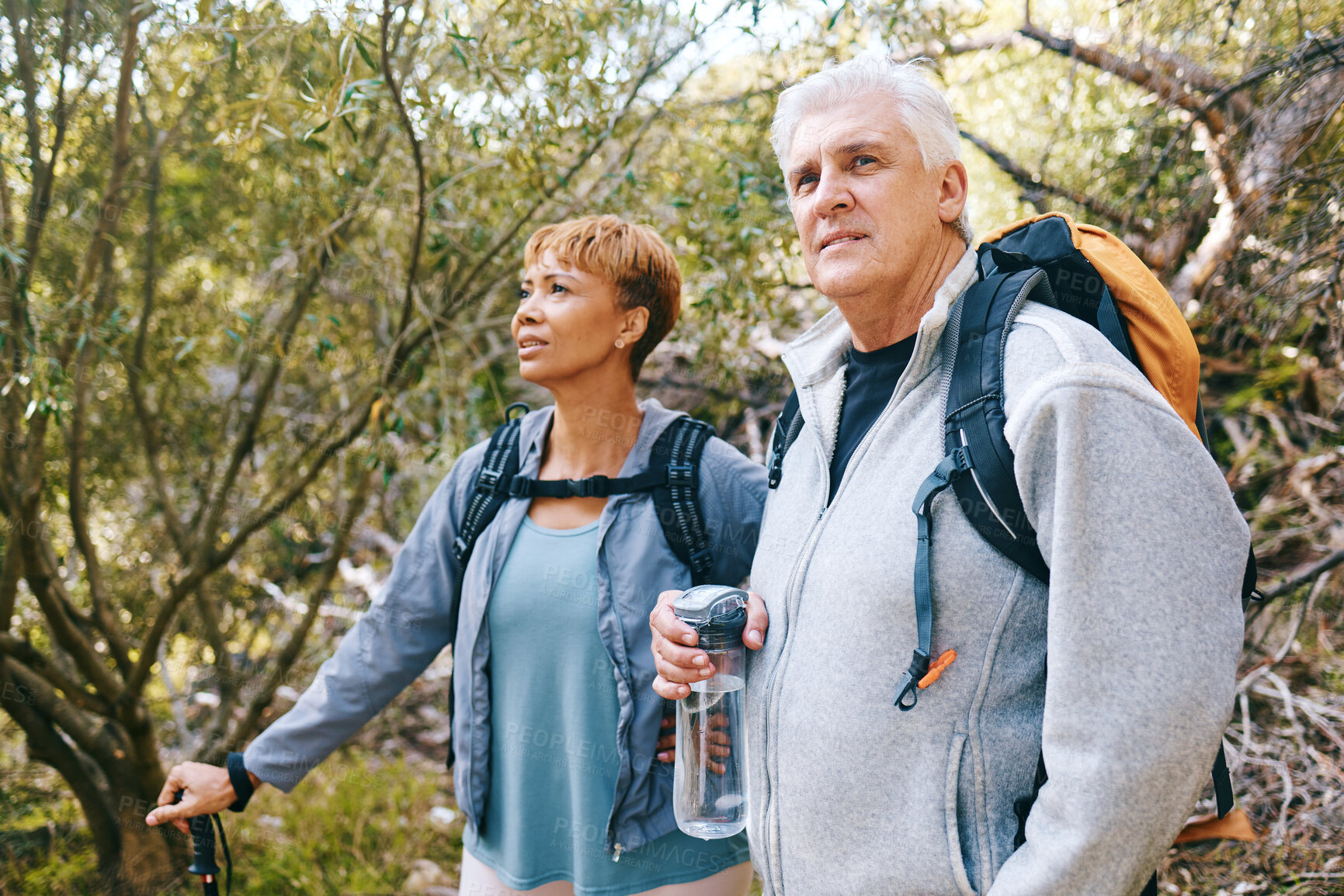 Buy stock photo Relax, senior or couple of friends hiking, walking or trekking for freedom, exercise or fitness in nature forest. Interracial, travel or happy woman enjoys bonding time with healthy elderly partner
