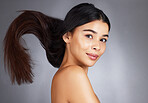 Woman, hair care and beauty in studio portrait for strong, healthy natural shine and wellness by background. Model, hair glow and cosmetic self care for health, self love and confidence by backdrop