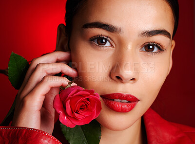 Buy stock photo Portrait, beauty and red rose with a model woman holding a flower in studio on a wall background for valentines day. Face, romance and love with an attractive young female posing to promote dating