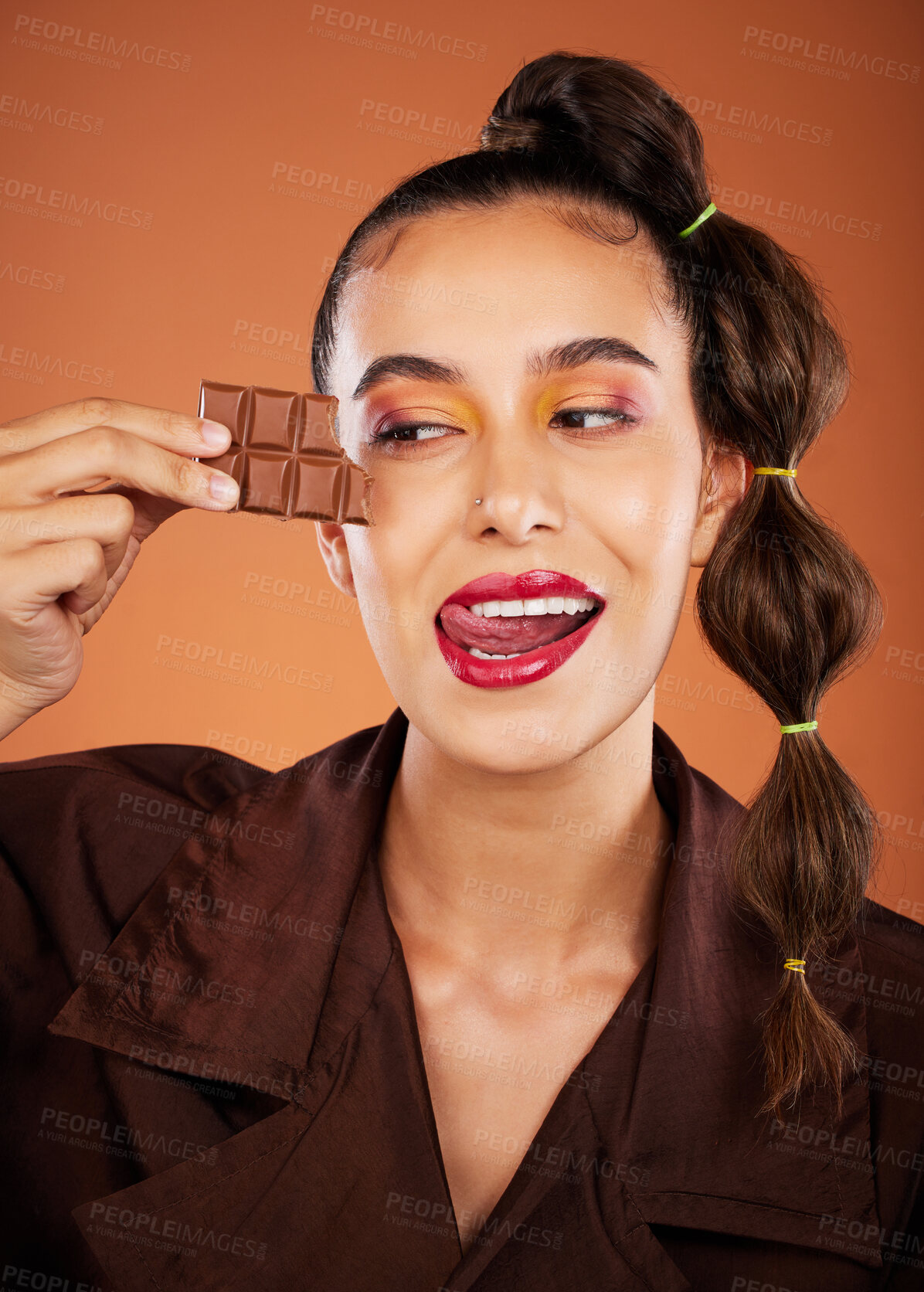 Buy stock photo Makeup, beauty and woman with face, chocolate and lipstick, tongue out and color with cosmetics. Candy, luxury and microblading with skincare, sweets with hair care and lips against studio background