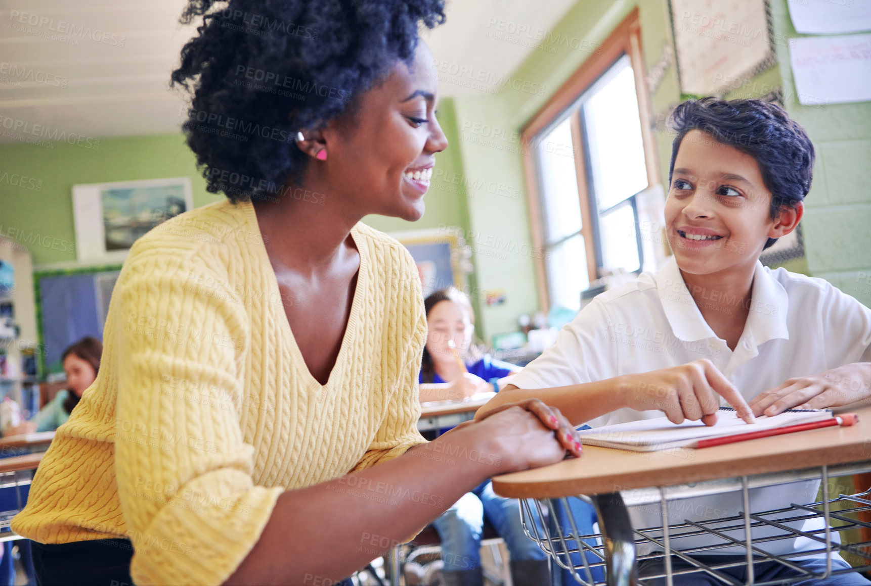 Buy stock photo Education, learning and teacher help student with assignment in elementary school. Classroom support, scholarship and happy black woman or educator aid, explaining and helping boy learner in class.