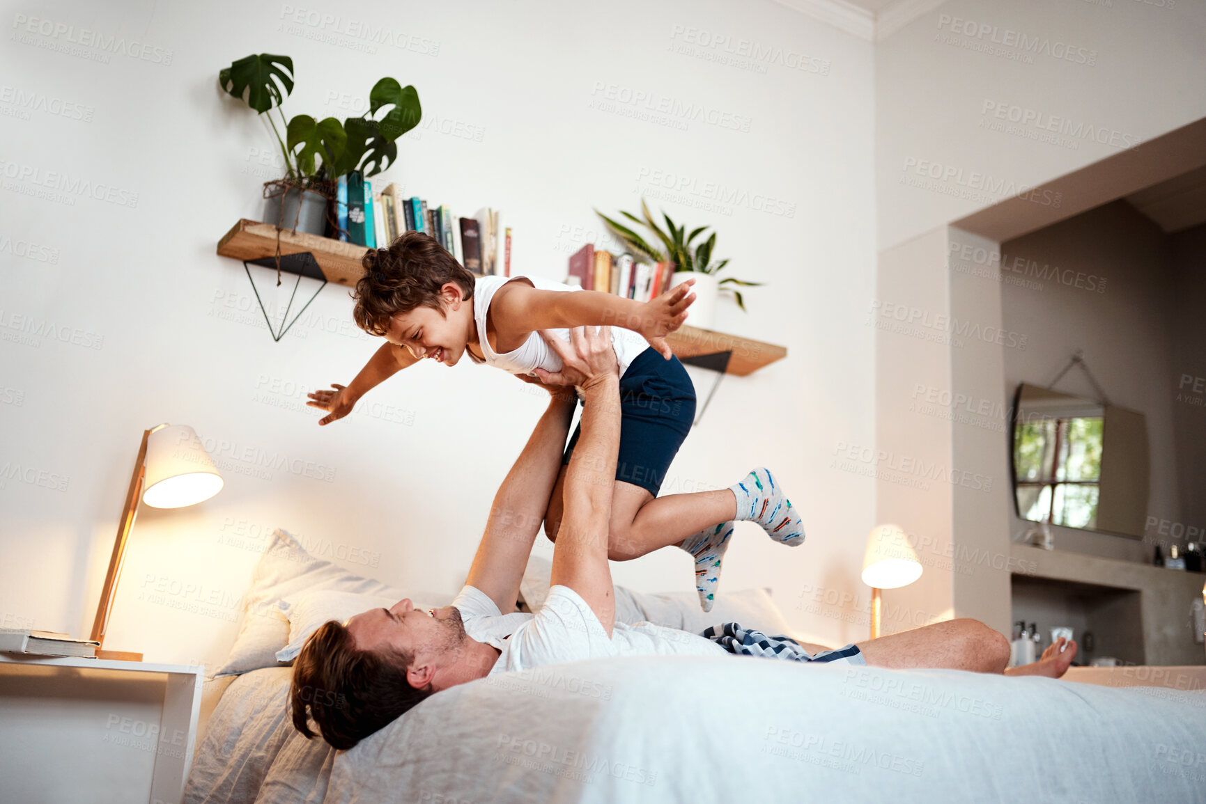 Buy stock photo Shot of a man and his son being playful before bedtime