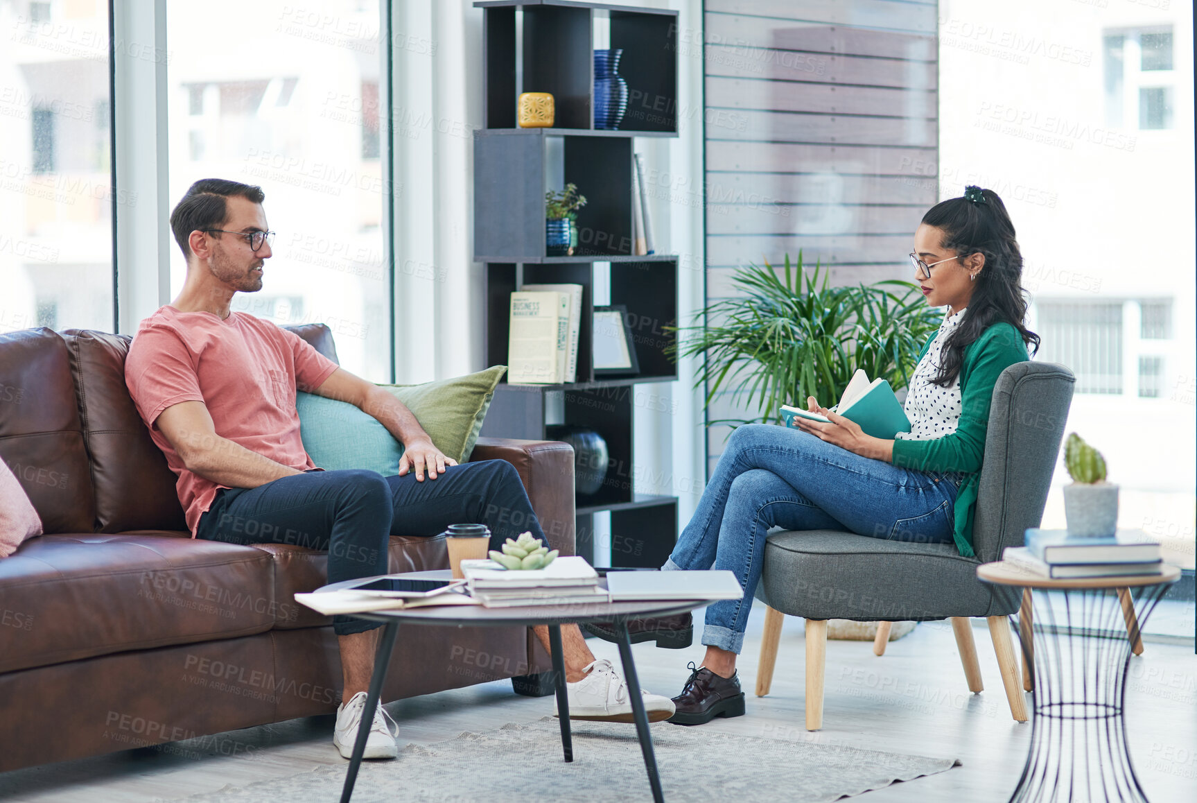 Buy stock photo Shot of a young man and woman having a discussion in a modern office