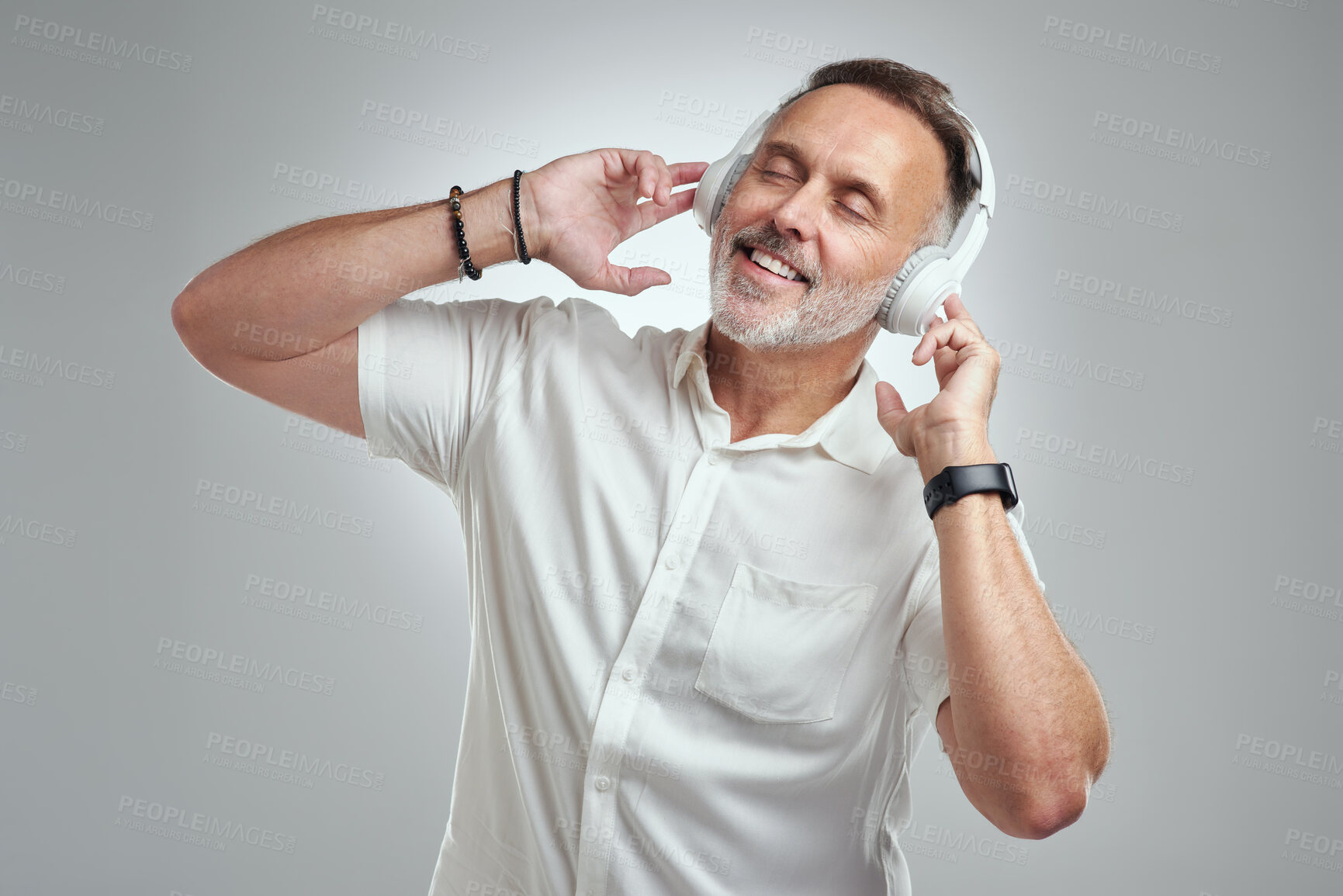 Buy stock photo Studio shot of a mature man wearing headphones against a grey background