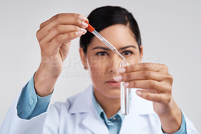Buy stock photo Cropped shot of an attractive young female scientist mixing samples in studio against a grey background