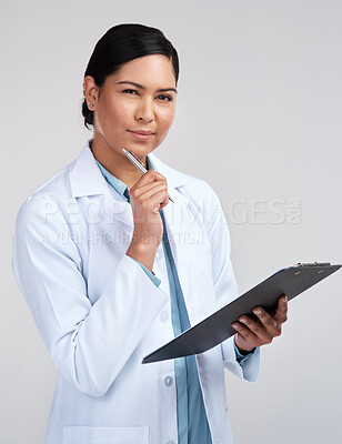 Buy stock photo Cropped portrait of an attractive young female scientist looking thoughtful while working on a clipboard in studio against a grey background