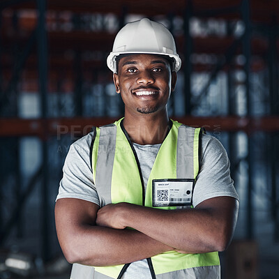 Buy stock photo Shot of a handsome young contractor standing alone in the warehouse with his arms crossed