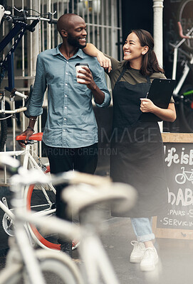 Buy stock photo Full length shot of two young business owners standing outside their bicycle shop during the day