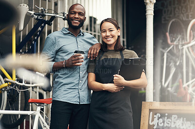 Buy stock photo Shot of two young business owners standing outside their bicycle shop during the day