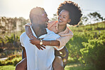 Black couple, piggy back or bonding in park, nature garden or sustainability environment in fun activity game or love. Smile, happy man or afro woman in carry support, trust or freedom playful date