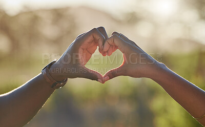 Heart, love hands and black couple in nature on holiday, trip or vacation. Romance, affection emoji and man and woman with sign or gesture for support, trust and care outdoors together on a date.