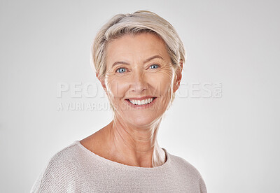 Buy stock photo Portrait of one happy caucasian mature woman isolated against a grey copyspace background. Confident smiling senior woman looking cheerful while showing her natural looking teeth in a studio