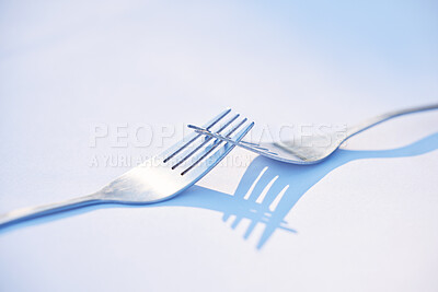 Buy stock photo Dinner, shadow and forks on a table for partnership, teamwork and collaboration on a blue studio background. Creative, design and kitchen utensils with reflection of solidarity and team work