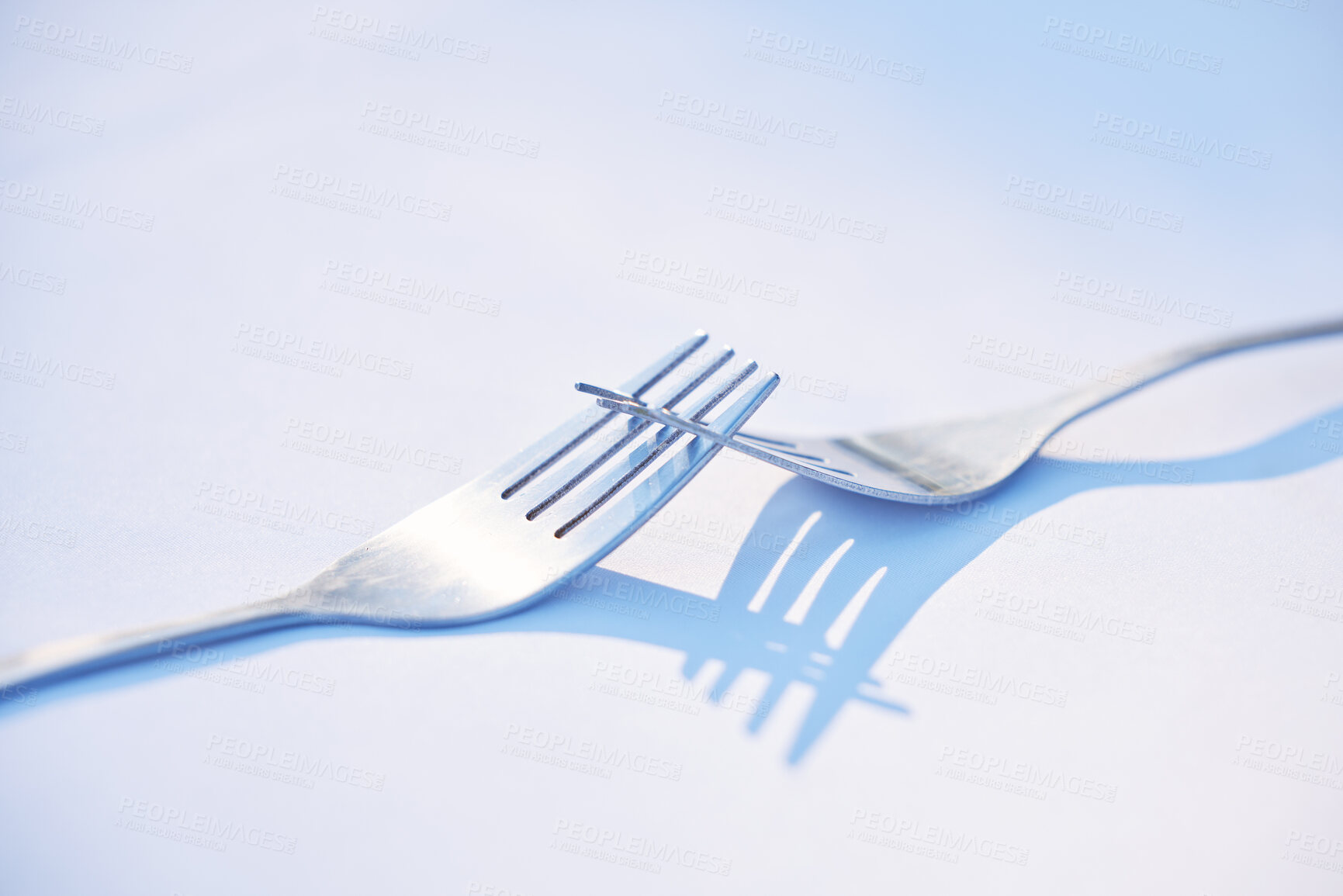 Buy stock photo Dinner, shadow and forks on a table for partnership, teamwork and collaboration on a blue studio background. Creative, design and kitchen utensils with reflection of solidarity and team work