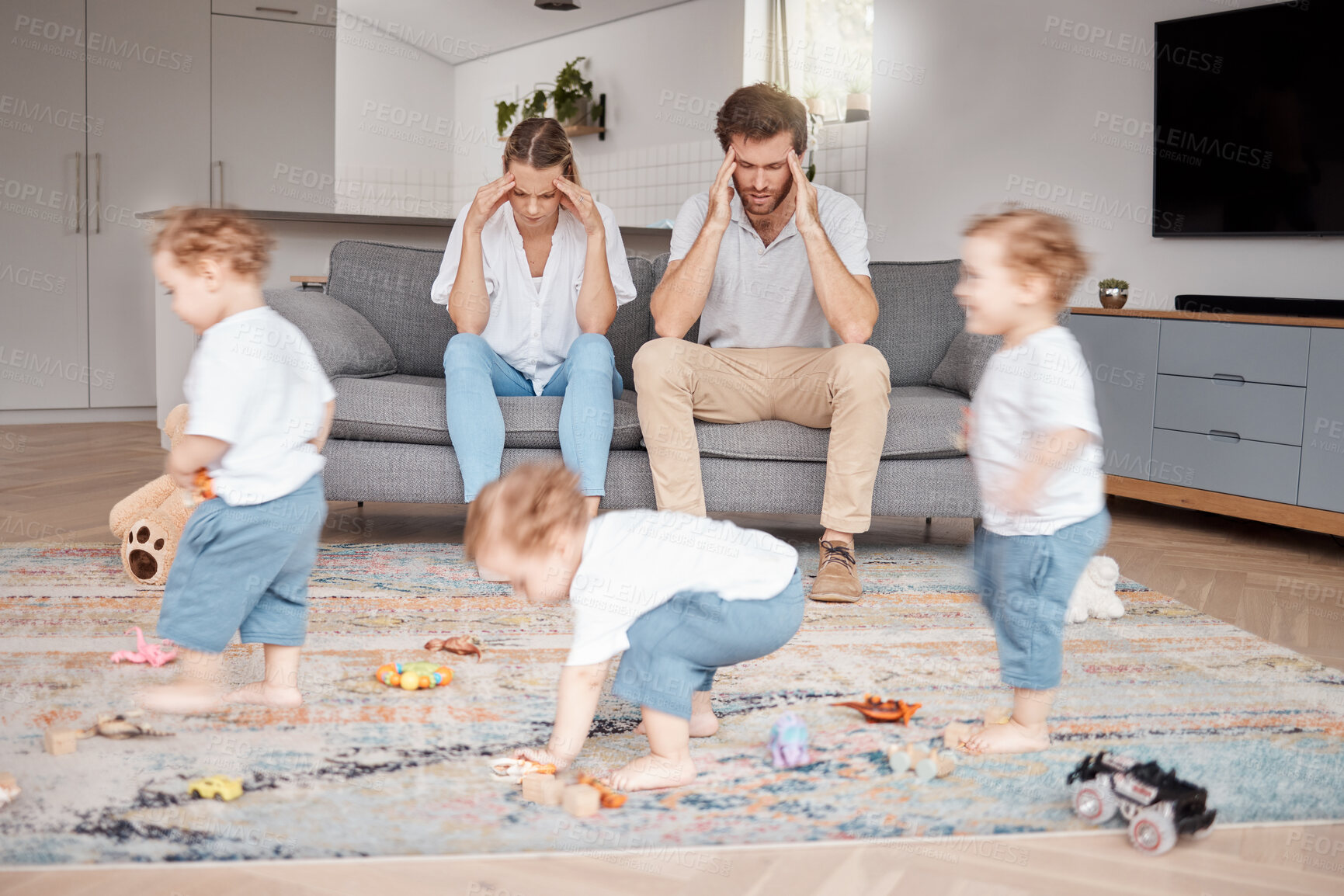 Buy stock photo Parents, stress and busy with an adhd child running around a home living room with energy or motion blur. Family children and headache with a hyperactive kid in a lounge with a stressed mom and dad