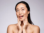 Asian woman, hands and face in beauty skincare for facial cosmetics or treatment against a studio background. Japanese woman smiling with tongue out in satisfaction for hygiene or perfect skin