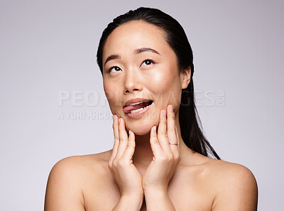 Buy stock photo Asian woman, hands and face in beauty skincare for facial cosmetics, botox or treatment against a studio background. Japanese woman smiling with tongue out in satisfaction for hygiene or perfect skin