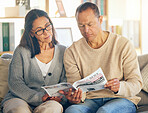 Senior couple, reading and newspaper on sofa, focus or relax together in morning for global event. Mature man, woman or media paper for international news, info or knowledge on couch in Florida