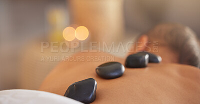 Buy stock photo Spa, man and stone massage to relax, luxury and health for body care, peace and holistic care. Male, gentleman and lying on table at resort, rocks and wellness therapy for skincare and stress relief.