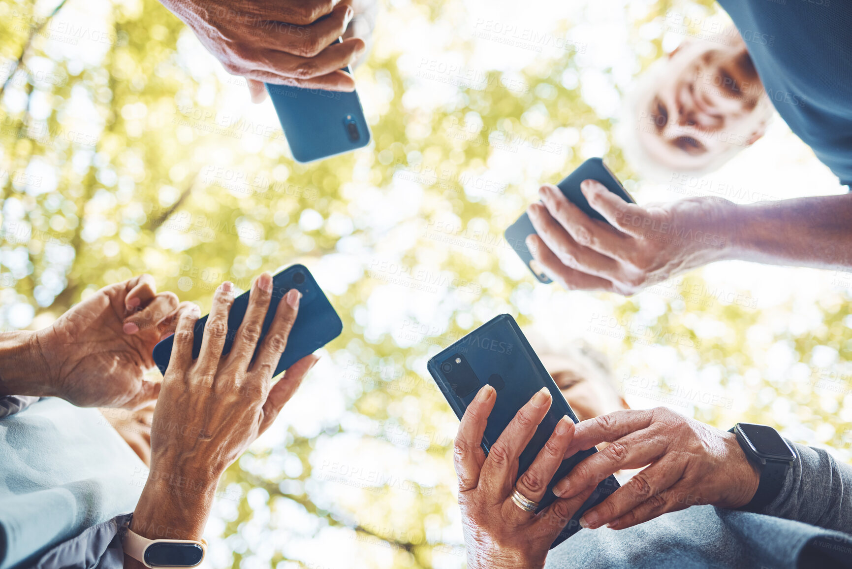 Buy stock photo Fitness, group with smartphone in hands and running in park, technology low angle and check exercise mobile app. Elderly runner team outdoor with health, senior and phone for cardio sports motivation