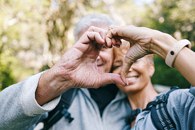Buy stock photo Heart, love hands and senior couple outdoors on vacation, holiday or hiking trip. Affection sign, romance emoji and elderly interracial couple, man and woman bonding together in nature on a hike.
