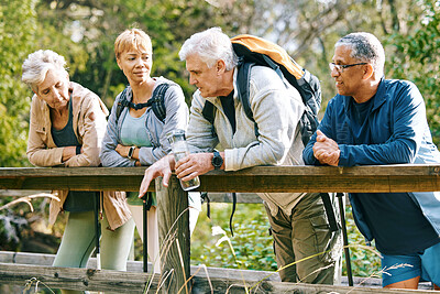 Buy stock photo Elderly, people hiking and happy in park with fitness outdoor, relax on bridge while trekking in nature together. Health, wellness and hiker group, sport and active lifestyle motivation with cardio.