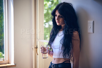 Buy stock photo Mental health, depression and sad woman thinking with water, stress and anxiety in a house. Depressed, lonely and goth girl with a drink, emotional and comtemplating problems in the lounge of home